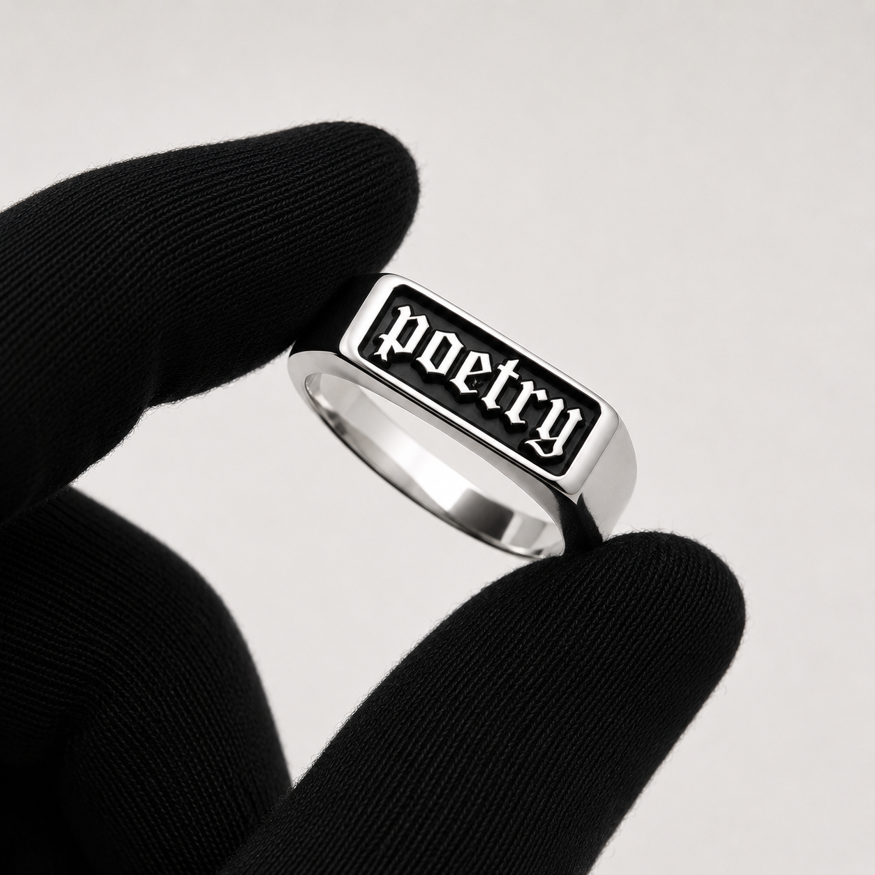Poetry signet ring held between fingers — ANANAS